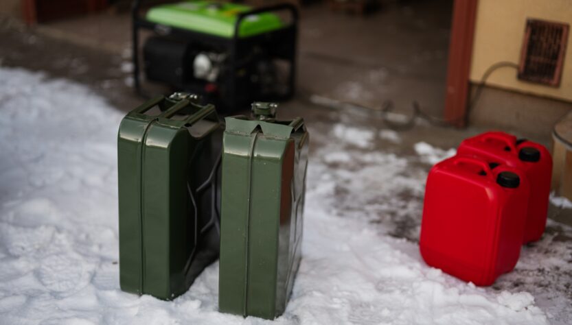 Сanisters with gasoline against portable mobile backup standby generator.