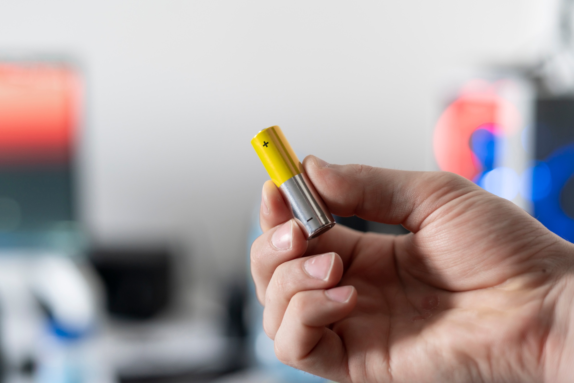 a hand holding the charged electric alkaline aa battery